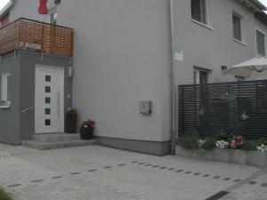 a white building with a door and a fence at Ferienwohnungen Flora in Bad Windsheim