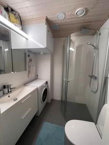 a bathroom with a shower and a washing machine at Ingas, Espoo- Whole apartment in Espoo
