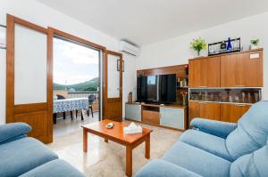 un soggiorno con due divani blu e un tavolo di YourHouse Sol i Mar 1 beach apartment a Cala Mesquida