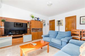 a living room with a blue couch and a tv at YourHouse Sol i Mar 1 beach apartment in Cala Mesquida