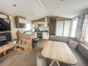 sala de estar con sofá y mesa en Lovely Caravan With Decking Wifi At Dovercourt Park, Essex Ref 44003bv, en Great Oakley