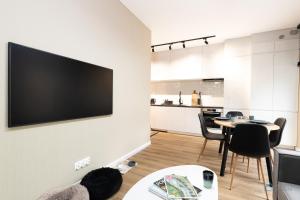 sala de estar con TV de pantalla plana en la pared en Garden Studio by 3City Rentals en Gdynia