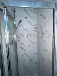 a shower with a glass door in a bathroom at OYO Greenway Stays in Uxbridge