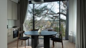 a dining room with a table and a large window at Holistic Skin & Wellness SPA Apartments in Birštonas