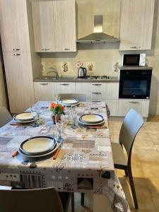 a kitchen with a table with plates and flowers on it at Seaside Zerilli Apartment - XI Febbraio in Santa Flavia