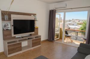 sala de estar con TV y ventana grande en Huemul, cálido y espacioso, aroma de mar en Puerto Madryn