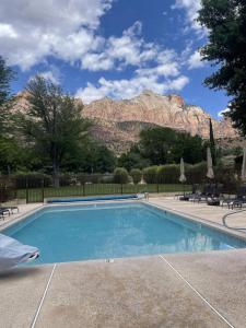 a swimming pool with a mountain in the background at Driftwood Lodge in Springdale