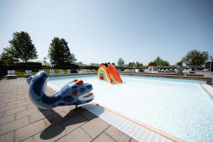 ein Schwimmbecken mit zwei Rutschen und einer Poolnudel in der Unterkunft Vakantiepark de Molenhoek in Kamperland