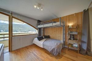 a bedroom with a bunk bed and a large window at Studio 5 Pers Face Au Lac Payolle in Campan