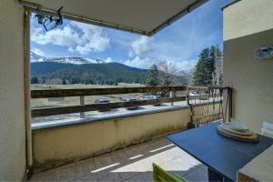 a balcony with a table and a view of a mountain at Studio 5 Pers Face Au Lac Payolle in Campan