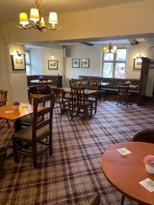 een eetkamer met houten tafels en stoelen bij The bucks head hotel in Church Stretton