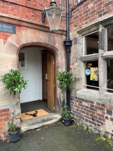 una entrada a un edificio de ladrillo con dos macetas en The bucks head hotel, en Church Stretton