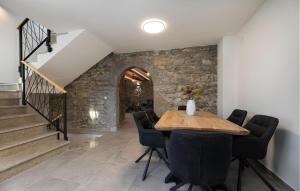 LakmartinにあるAwesome Home In Lakmartinの石壁のダイニングルーム(テーブル、椅子付)
