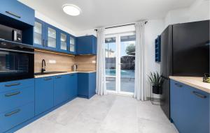 LakmartinにあるAwesome Home In Lakmartinのキッチン(青いキャビネット付)、大きな窓