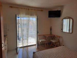 a bedroom with a bed and a table and a balcony at Apartments Marjanovic in Bol