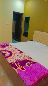 Un dormitorio con una cama con una manta rosa. en OYO Hotel Oyo Sky Hills Near Chaudhary Charan Singh International Airport en Bijnaur
