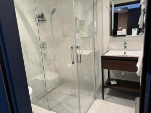 un bagno con doccia e lavandino di Skyline Hotel City Frankfurt a Francoforte sul Meno