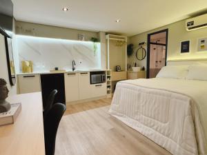 a bedroom with a large bed and a kitchen at Apê Paulista Alameda Santos in São Paulo +34 photos