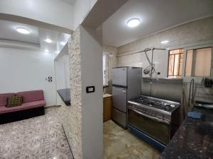 a kitchen with a stainless steel refrigerator and a couch at Light moon appartment in Luxor