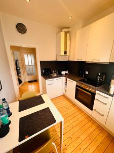 eine Küche mit weißen Schränken und Holzböden in der Unterkunft Schönes 2-Zimmer-Apartment in Bremen, Findorff in Bremen
