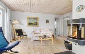 a living room with a couch and a fireplace at 3 Bedroom Awesome Home In Skagen in Skagen