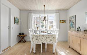 a dining room with a table and chairs and a window at 3 Bedroom Awesome Home In Skagen in Skagen