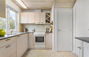 a kitchen with white cabinets and a stove at 3 Bedroom Awesome Home In Skagen in Skagen +11 photos