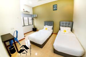 een kamer met 2 bedden en witte kussens bij QQ Seremban Lovely HomeStay10R 4B in Seremban