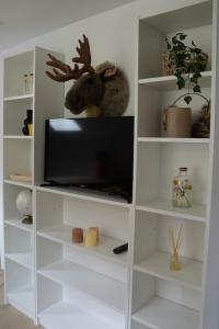 a white book shelf with a tv in it at Studio rénové dans le centre in Cauterets
