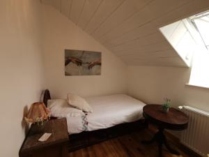 ein kleines Schlafzimmer mit einem Bett und einem Tisch in der Unterkunft Gîte les petits chemins in Ledeuix