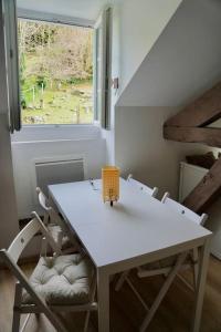 a white table and chairs in a room with a window at Studio rénové dans le centre in Cauterets