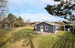 une petite maison dans une cour avec une aire de jeux dans l'établissement Awesome Home In Hadsund With Wifi, à Hadsund