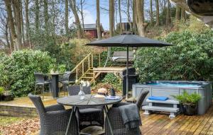 een tafel en stoelen met een parasol op een patio bij Nice Home In Brkop With House Sea View in Børkop