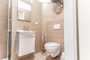 a bathroom with a toilet and a sink and a shower at Hauptbahnhof Boutique Rooms - Virtual Reception & Self-Checkin in Vienna