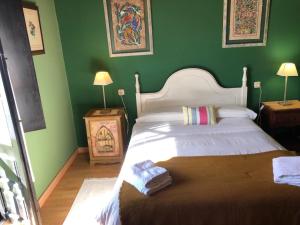 a bedroom with a large bed with green walls at Casa Lula 2 Pendueles Llanes in Llanes