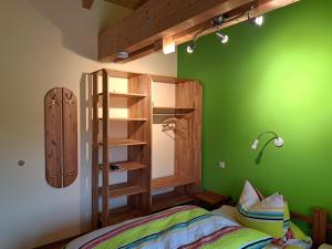 a bedroom with green walls and a bed and a shelf at Ferienwohnung Sonnenschein in Nagel