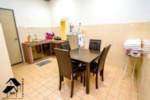 a kitchen with a table and chairs in a room at QQSweetHomeLovelyBktChedang10bedroom Homestay (15-17pax) in Seremban