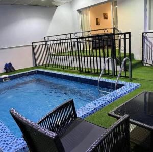 a pool with two chairs and a table and a table at شاليه منتجع هدا الأحلام in Al Hada