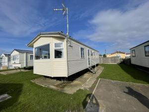 a tiny house is sitting in a yard at Brilliant 6 Berth Caravan At Dovercourt Holiday Park Ref 44009a in Great Oakley