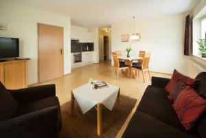 a living room with a couch and a table at Kur & Golf Ferienwohnungen Wattenbach in Bad Windsheim