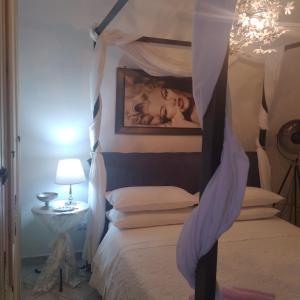een slaapkamer met een hemelbed en een foto van een baby bij Route 66 Motel GeA in Bolsena