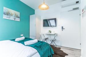 Schlafzimmer mit blauen Wänden, einem Bett und einem Schreibtisch in der Unterkunft Hauptbahnhof Boutique Rooms - Virtual Reception & Self-Checkin in Wien