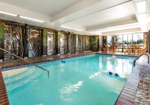 a swimming pool with blue water in a building at Bass Pro Shops Angler's Lodge in Springfield