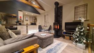 a living room with a couch and a christmas tree at Fox Corner, Ambleside, romantic retreat for two, dog friendly, hot tub in Ambleside