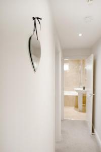 un bagno con specchio a forma di cuore sul muro di Stamford Apartment, Central, Quiet a Southport