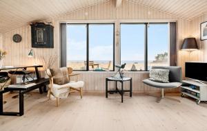 uma sala de estar com janelas, uma secretária e cadeiras em 2 Bedroom Gorgeous Home In Nykbing Sj em Klint