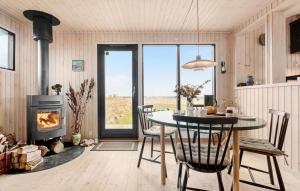 uma sala de jantar com uma mesa e uma lareira em 2 Bedroom Gorgeous Home In Nykbing Sj em Klint