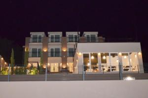 - un grand bâtiment blanc avec des lumières devant dans l'établissement Residence Spa Apartments DUB, à Kotor
