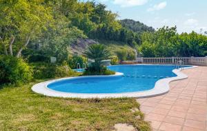 a swimming pool in a yard with a patio at Beautiful stacaravan In Xtiva With Kitchenette in Xàtiva