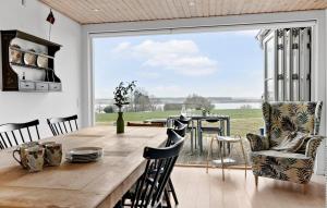 a dining room with a table and a large window at Beautiful Home In Skibby With House Sea View in Skibby